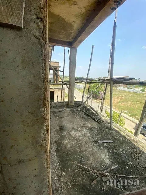 An unfinished balcony looking down an estate road and open grassland
