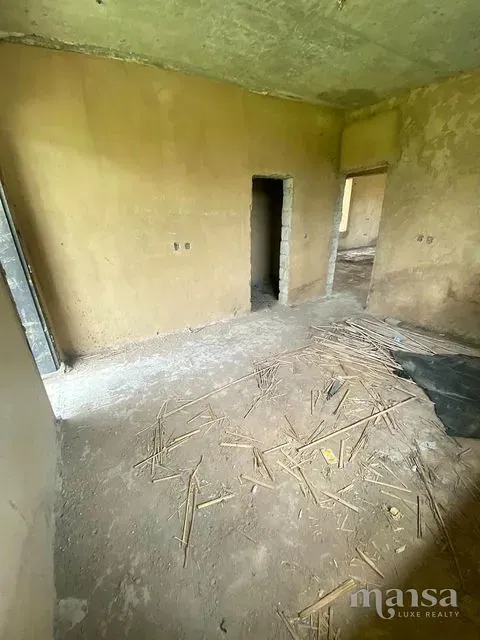 An unfinished plastered room with a doorway