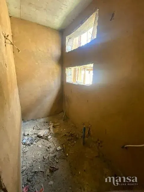 A smaller unfinished room with high window openings
