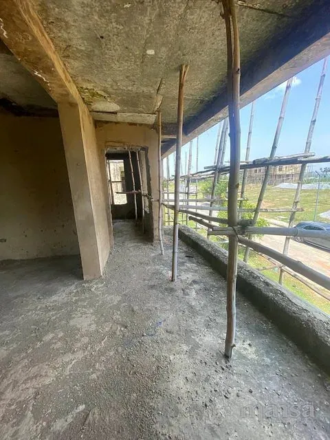 An upper-floor room with openings along one side behind scaffolding