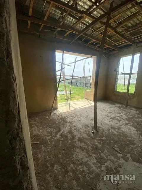 A top-floor room with a timber roof frame and roofing sheets overhead
