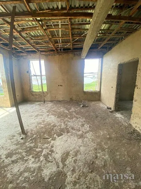 A top-floor room with two window openings under the timber roof frame