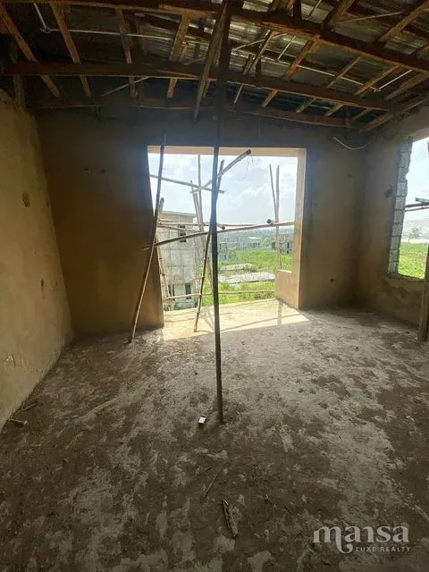 A top-floor room with a wide opening onto a balcony and bamboo props