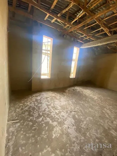 A top-floor room with two tall narrow windows under the timber roof frame