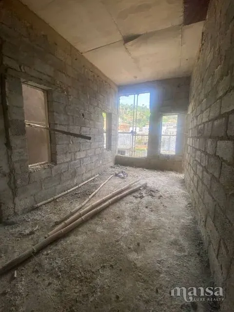 A narrow passage between block walls ending at a window opening