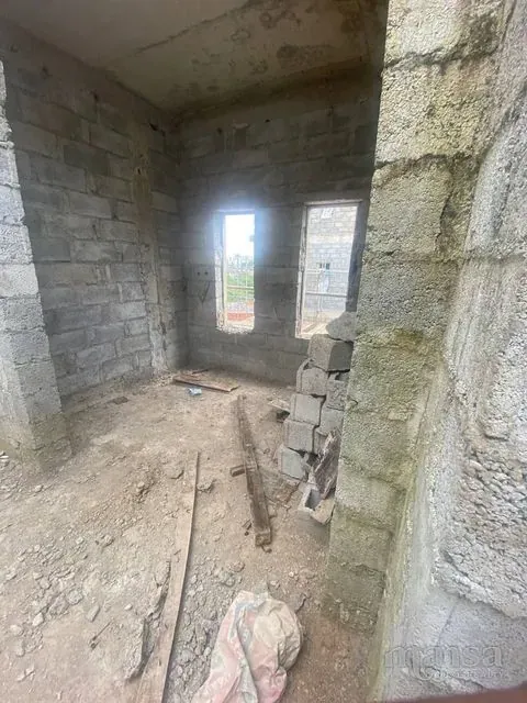 An unfinished room with a tall window opening