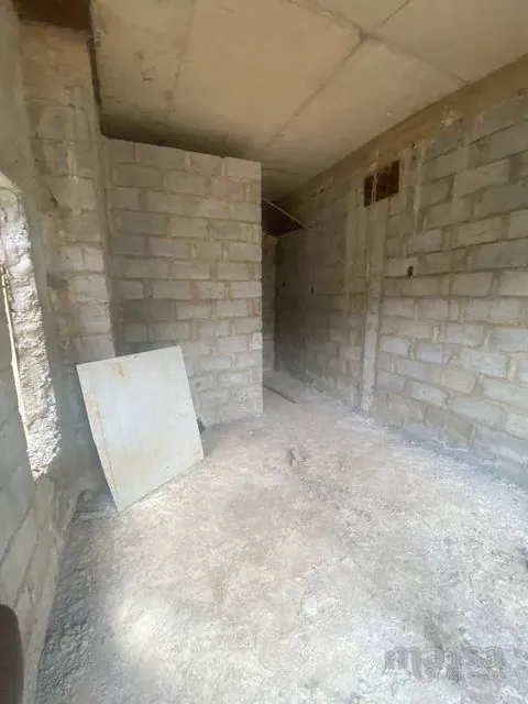 A smaller unfinished room with bare block walls