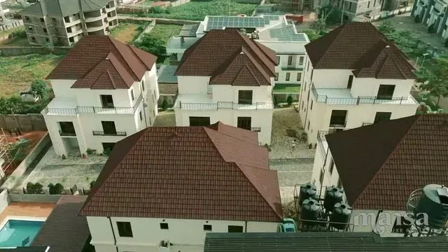 Aerial view of white detached duplexes with red-brown roofs in a mini estate in Katampe Extension