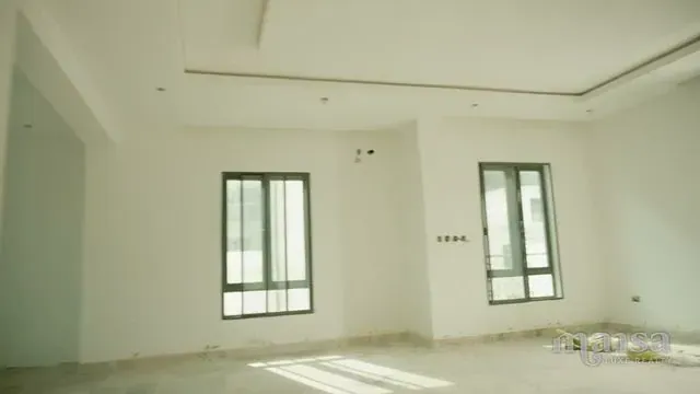 An empty room with white walls, two windows and a recessed ceiling detail