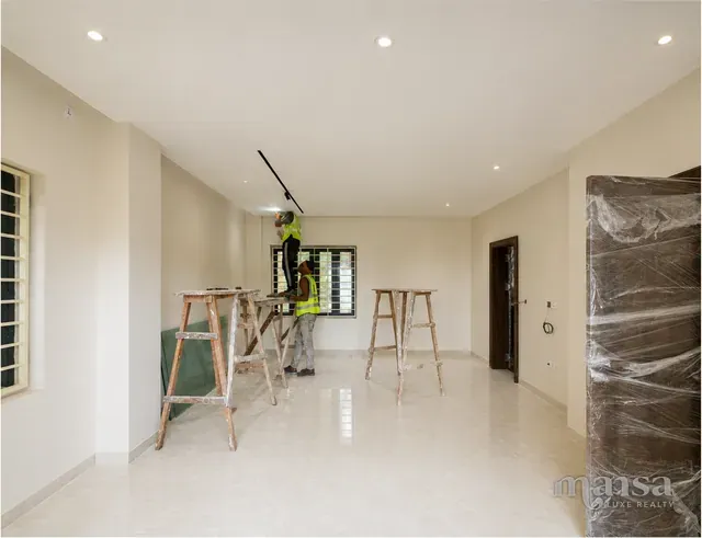 A bedroom in the Katampe Extension house during finishing work, with the crew on trestles