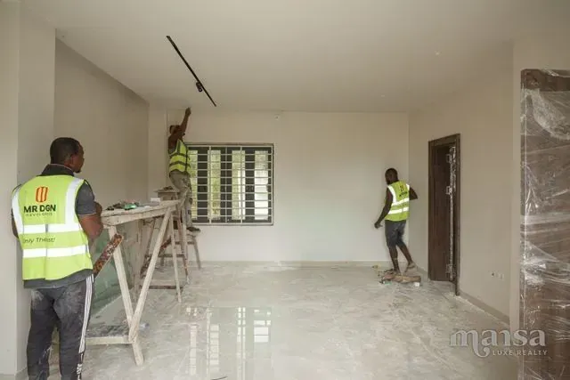 MR DGN Construction crew in branded high-visibility vests finishing an interior of the Katampe Extension house