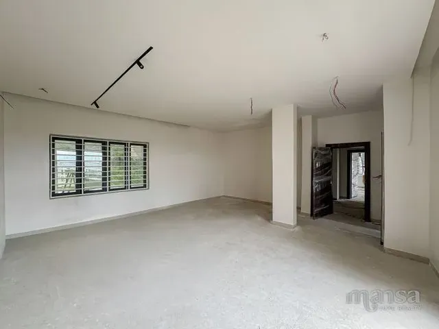 An interior room of the Katampe Extension house during construction, plastered and awaiting its floor finish