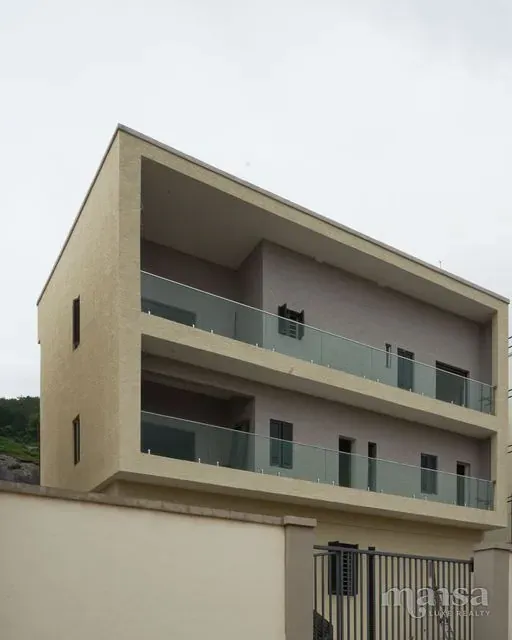 The front of the 5-bedroom standalone house in Katampe Extension, Abuja during the build, a three-storey house with glass balcony balustrades behind its own walled compound and gate