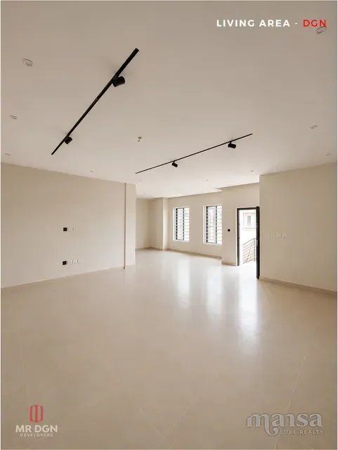 The main living area of the Katampe Extension house before completion, with black track lighting and porcelain tiled floors